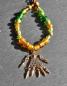 Preview: Keltische Glasperlenkette in grün und gold - Fibelkette mit Klapperanhänger aus Bronze von Belanas Schatzkiste im Sonnenlicht